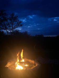 a fire is burning in a field at night at Kufihliwe Lodge in Ingogo
