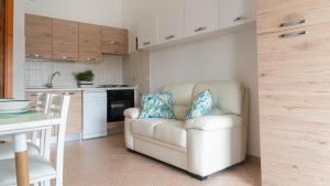a living room with a white couch and a kitchen at La Casa di Asia in Tanaunella