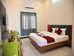 um quarto com uma cama grande com travesseiros vermelhos em The Rose Bagh Resort Pushkar em Pushkar