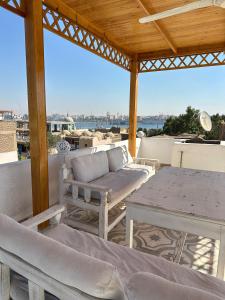 a patio with a couch and a table on a roof at Temple House Luxor in Luxor