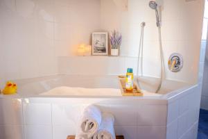 bagno con vasca, doccia e asciugamani. di Helle Wohnung mit Seeblick a Tutzing Altre 32 foto