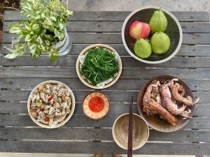 a table with bowls of food and fruits and vegetables at Pepper In Nha Trang Homestay in Nha Trang +23 photos