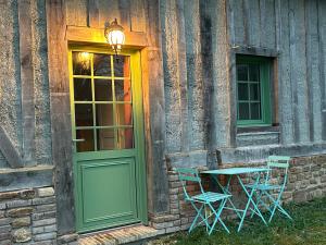 a table and chairs next to a building with a door at Pomme d'Amour in Vimoutiers