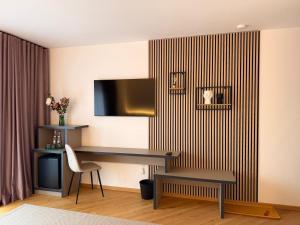 a room with a desk and a television on a wall at Marmotta Paltinis in Păltiniş