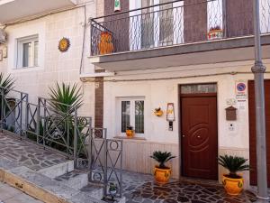 a building with a brown door and a balcony at bed & breakfast Acquaviva di Vullo Vincenzo in Acquaviva Platani