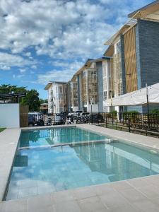 a swimming pool at a apartment complex with condos at Cozy Condo near Mactan Airport - Free Wifi! in Lapu Lapu City