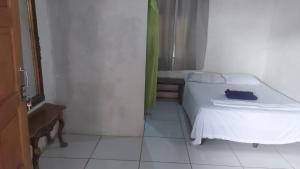 リバスにあるHostal Brisas del Ometepe Habitación 4の白いベッドと窓のある小さな寝室