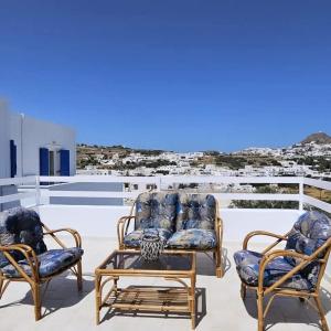 two chairs and a table on top of a roof at SUNSET VILLA MILOS pera triovasalos in Triovasálos