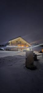 Un gran edificio con luces por la noche. en Chalet Gabriela, en Şarul Dornei