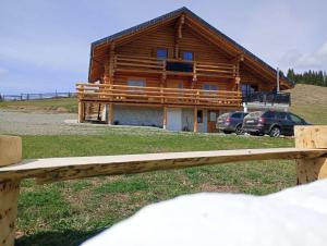 una cabaña de madera con coches estacionados frente a ella en Chalet Gabriela, en Şarul Dornei 15 fotos más