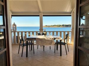 a dining room with a table and chairs on a balcony at City Center Coastal Escape - Apartments with Sea View or Cozy Room in Novigrad Istria