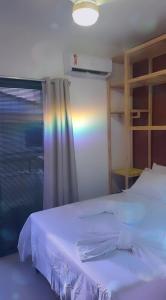 a bedroom with a white bed and a window at Triplex Flecheiras in Flecheiras