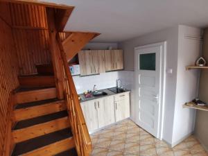Una cocina con una escalera que conduce a la cocina. en Casuta -Maria-Kisház, en Sovata 5 fotos más