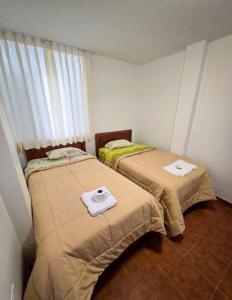 two beds sitting next to each other in a room at Hospedaje Wendy in Puerto Chicama