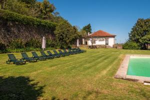 a row of lawn chairs next to a swimming pool at Casa de Vilela - casa senhorial exclusiva perto do Porto para até 15 pessoas in Santo Tirso
