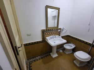 een badkamer met een wastafel, een toilet en een spiegel bij Art house Venusio luxury home in Napels +9 foto's