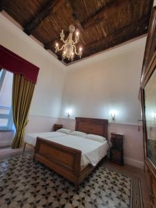 een slaapkamer met een bed en een kroonluchter bij Art house Venusio luxury home in Napels