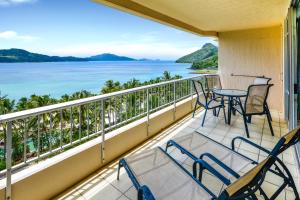 einen Balkon mit Stühlen, einem Tisch und Meerblick in der Unterkunft Whitsunday Apartments on Hamilton Island by HIHA in Hamilton Island