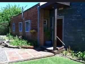 a brick house with a porch and a door at Nupalembe in Ezeiza +4 photos