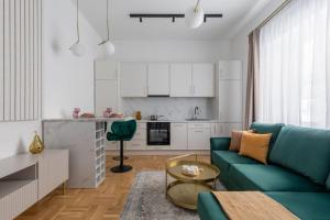 a living room with a green couch and a kitchen at GOLDENGREEn in Sibiu