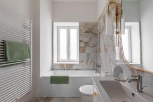 a bathroom with a tub and a toilet and a sink at GOLDENGREEn in Sibiu