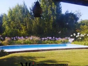a garden with a swimming pool and flowers at Nupalembe in Ezeiza