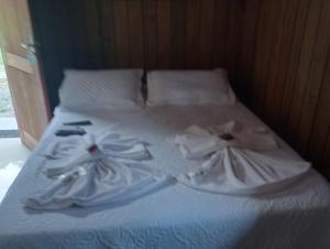 a bed with white sheets and towels on it at Trento Chalés in Nova Trento +29 photos