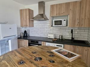 a kitchen with a wooden table in the middle of it at Vos vacances à 3 minutes de la mer in Belgodère