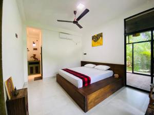une chambre avec un lit et un ventilateur de plafond dans l'établissement Ayubowan Eco Lodge, à Kandy