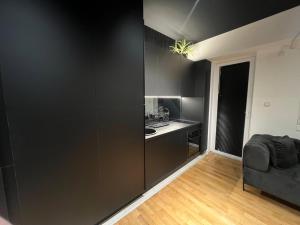 a kitchen with black cabinets and a chair in a room at Demo Apartments Black II in Bitola