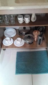 a shelf with plates and cups and dishes on it at Trento Chalés in Nova Trento