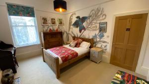 a bedroom with a bed and a wall with a bird mural at Church Retreat - A Magnificent Seaside Apartment-Award Winning in Hastings