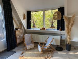 a living room with two chairs and a window at Woodhouse Durbuy nr. 141 in Durbuy +62 photos
