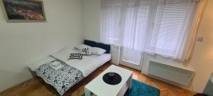 een kleine slaapkamer met een bed met een zwart-witte deken bij Vista Studio Apartment in Brčko