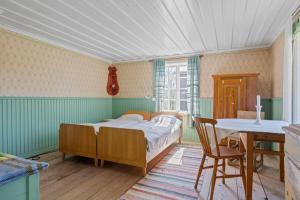 a bedroom with a bed and a desk and a table at Allsta Gård in Bjärtrå