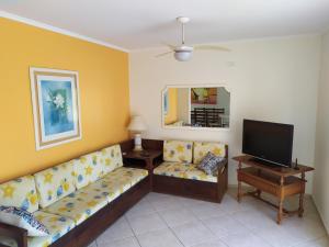 a living room with a couch and a television at Sobrado charmoso 2 in Guaratuba