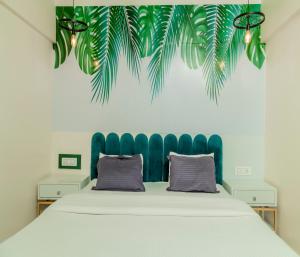 a bed with a blue tufted headboard in a room at Copper 11 Service Apartments -SB Road, Shivaji Nagar, Pune in Pune