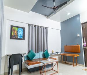 a living room with a couch and a table at Copper 11 Service Apartments -SB Road, Shivaji Nagar, Pune in Pune