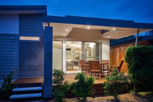 a house with a deck with chairs and a table at Ingenia Holidays Byron Bay in Byron Bay