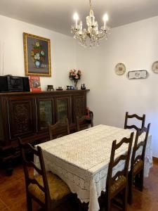 Puente-CastreloにあるMaison familiale avec vueのテーブルと椅子とシャンデリアのあるダイニングルーム