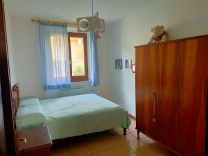 a bedroom with a bed and a dresser and a window at La casa di Cleo in Castiglione del Lago