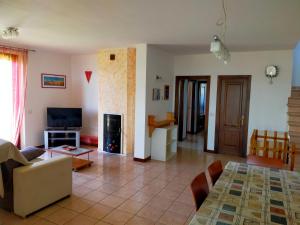a living room with a couch and a tv at La casa di Cleo in Castiglione del Lago