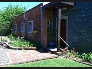 a brick house with a front porch and a door at Nupalembe in Ezeiza