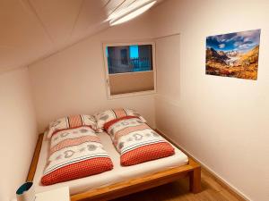 un piccolo letto in una piccola stanza con finestra di Ferienwohnung in Mörel a Mörel