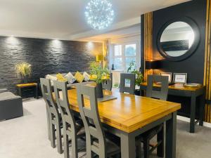 a dining room with a wooden table and chairs at Apartment 3 Benllech with Sea views in Benllech