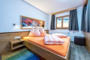 a bedroom with a bed with pink pillows on it at AlpenLiving in Mayrhofen