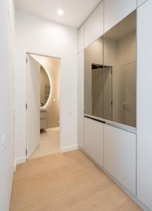 a hallway with white cabinets and a bathroom at Caffe Luxury king bed Entire Apartment, underground Parking near Promenada Bussiness Center in Bucharest