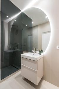 a bathroom with a sink and a shower at Caffe Luxury king bed Entire Apartment, underground Parking near Promenada Bussiness Center in Bucharest +42 photos