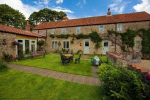 a house with a yard with a table and chairs at Bilsdale Cottage in Helmsley