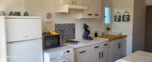 a kitchen with a white refrigerator and a dishwasher at Appartement-1- prive, terrasse, parking et jardin in Le Boulou